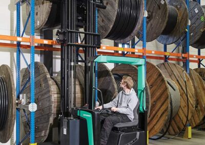 man in a reach truck lifting materials